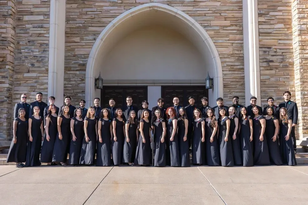 Singers in black in front of chruch