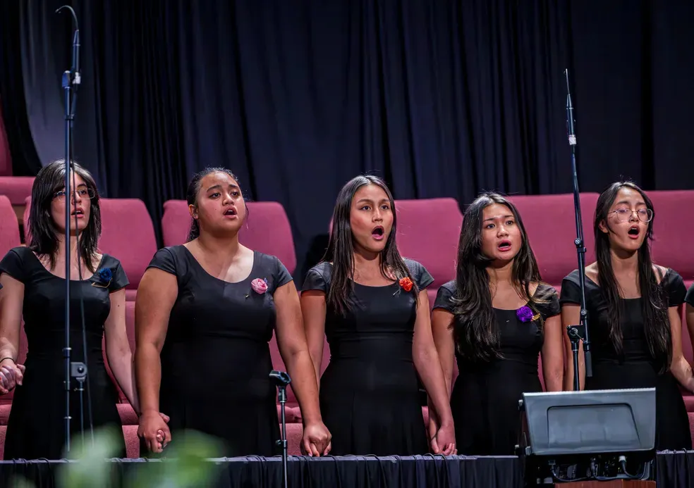 Five singers in front of chairs