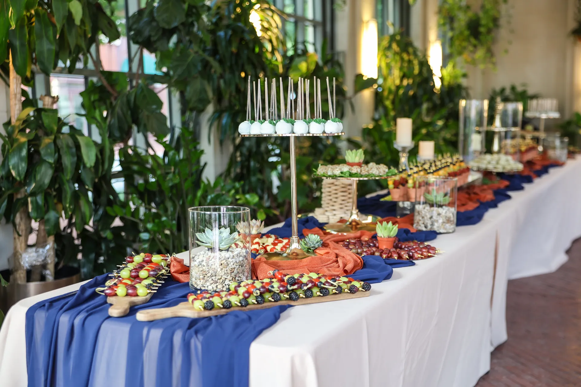  Buffet table arrayed with finger foods, cake pops, and candles