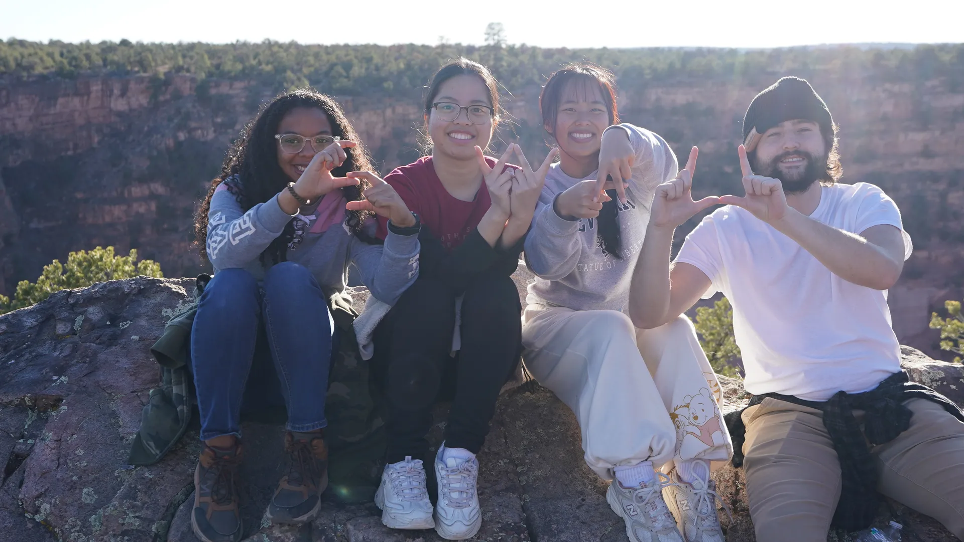 Four students sitting on rocks