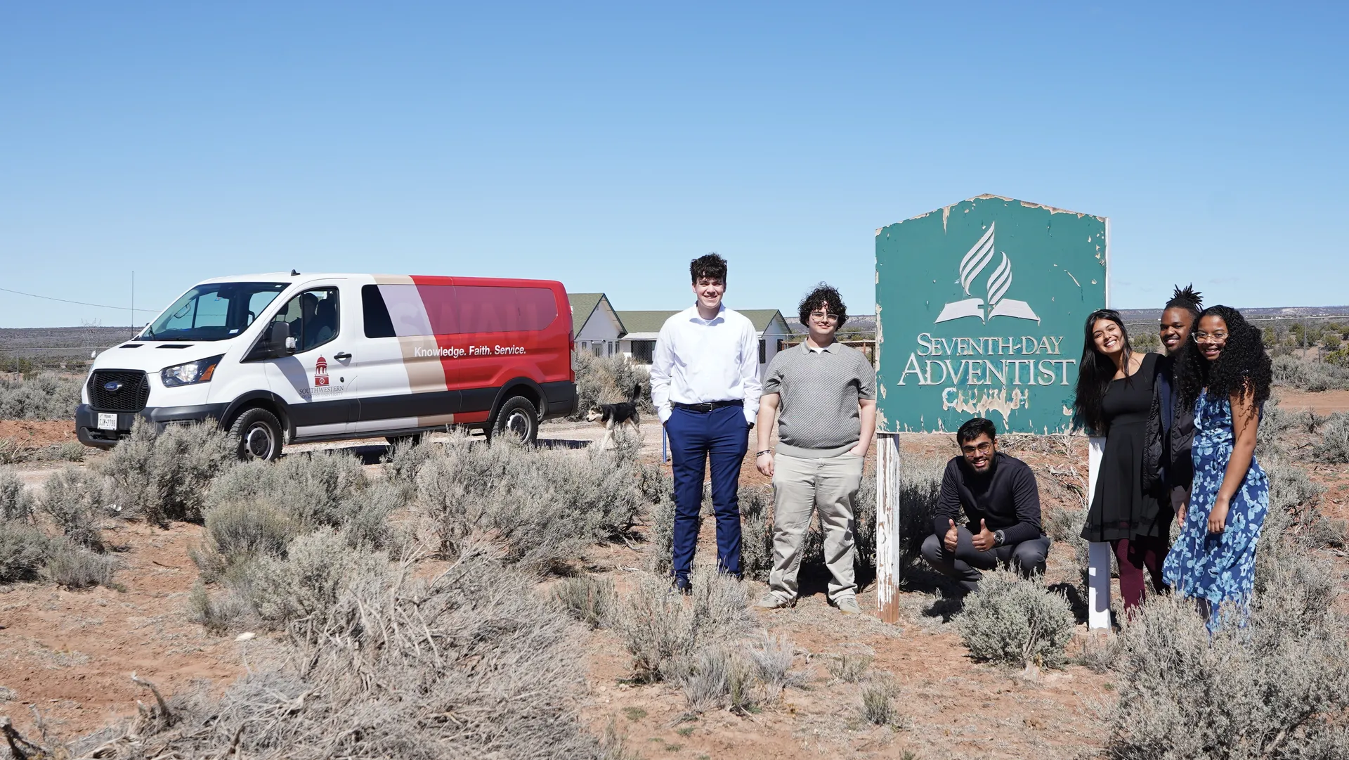 Six students in front of the Kinlichee SDA church sign