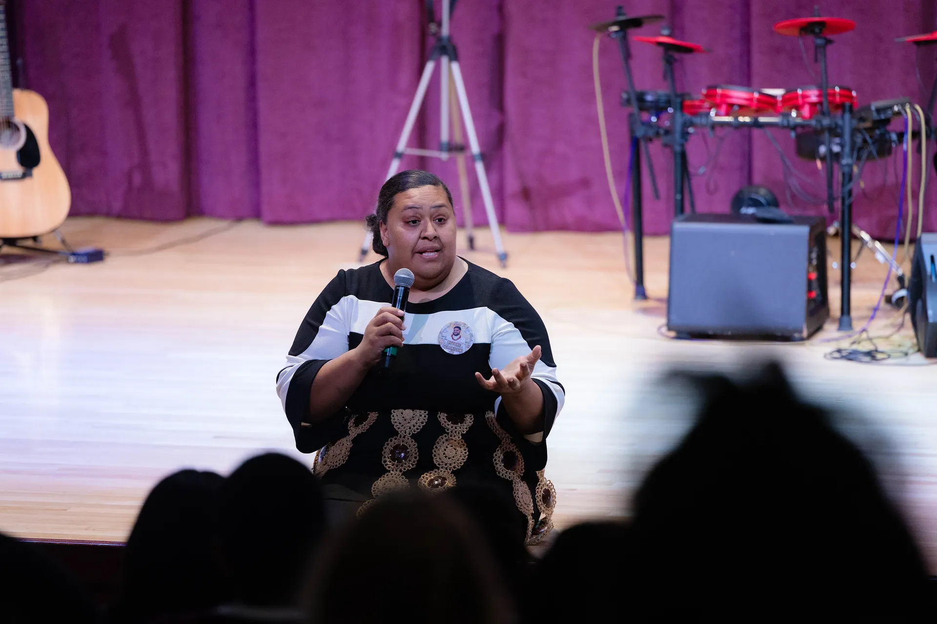 woman sitting on stage speaking