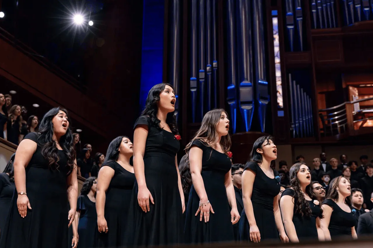 Several female singers in black dresses lined up in rows