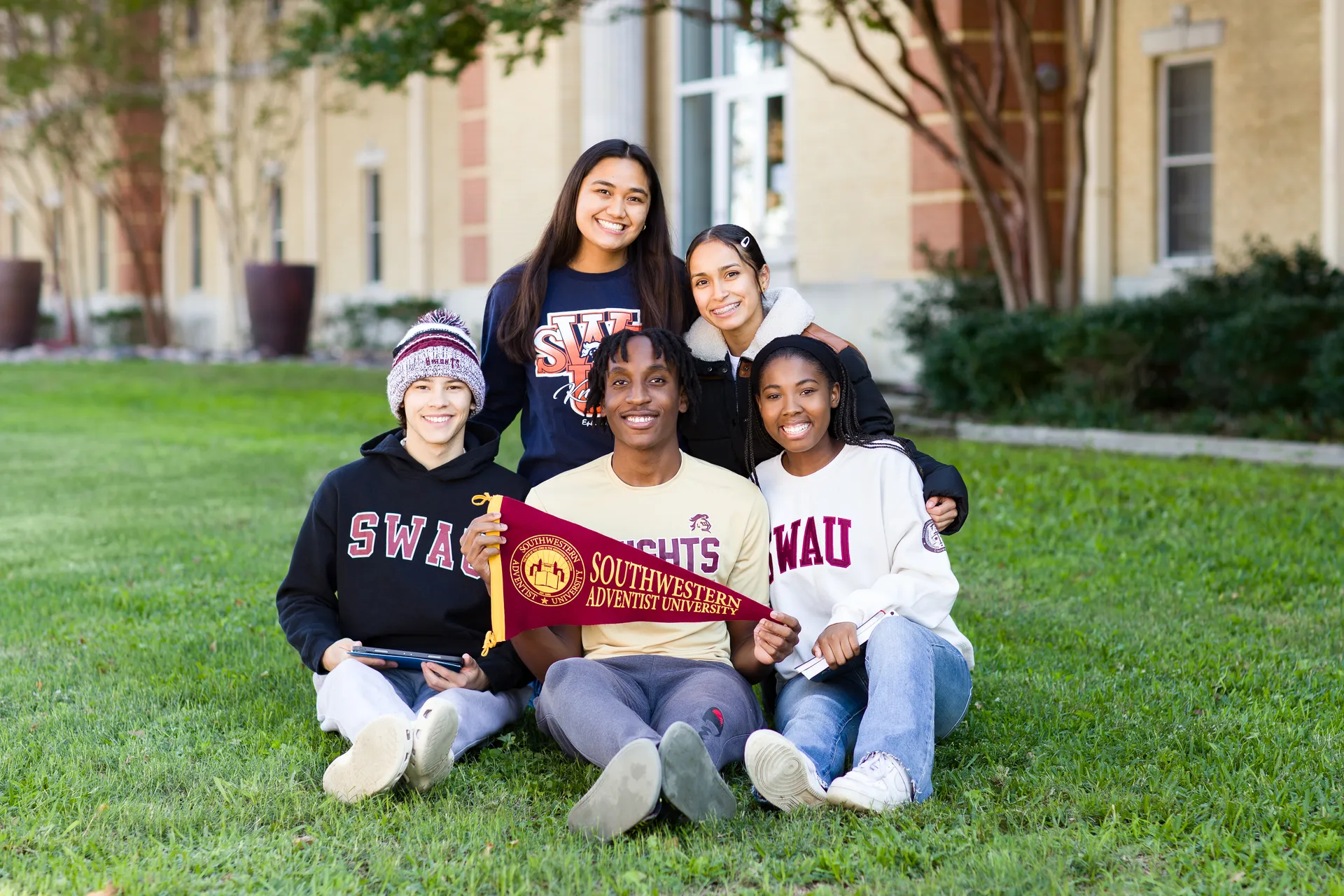 Students Sitting on Lawn with Pennant Flag