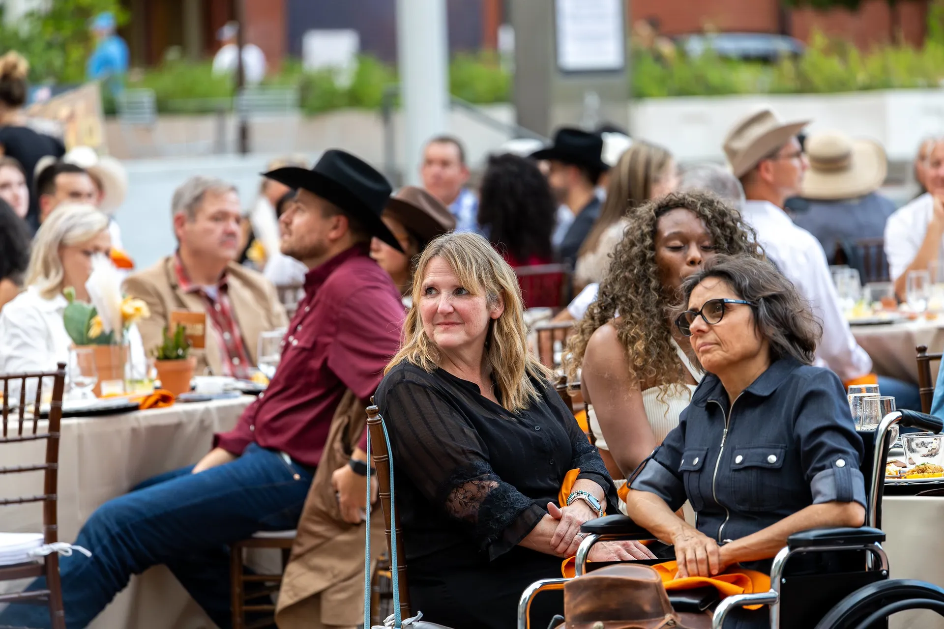People sitting in chairs surrounded by dining tables