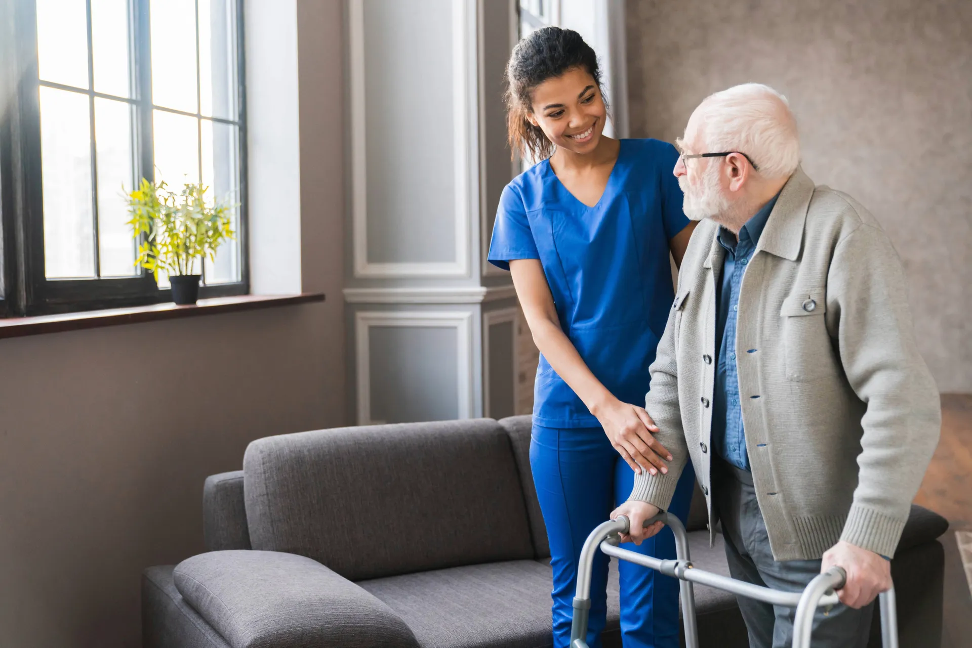 Nurse helping elderly man with walker