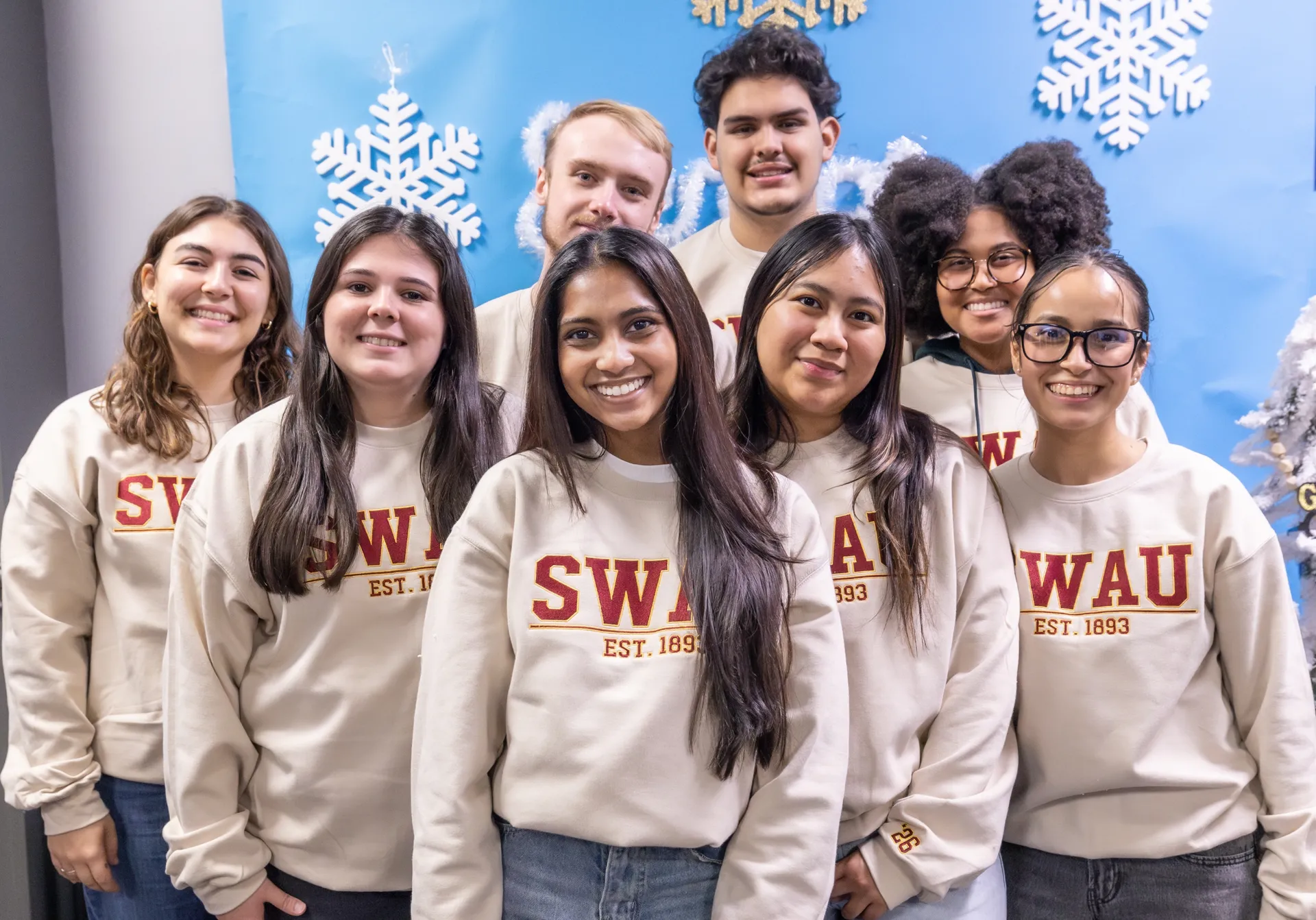 students in swau sweaters in front of winter background