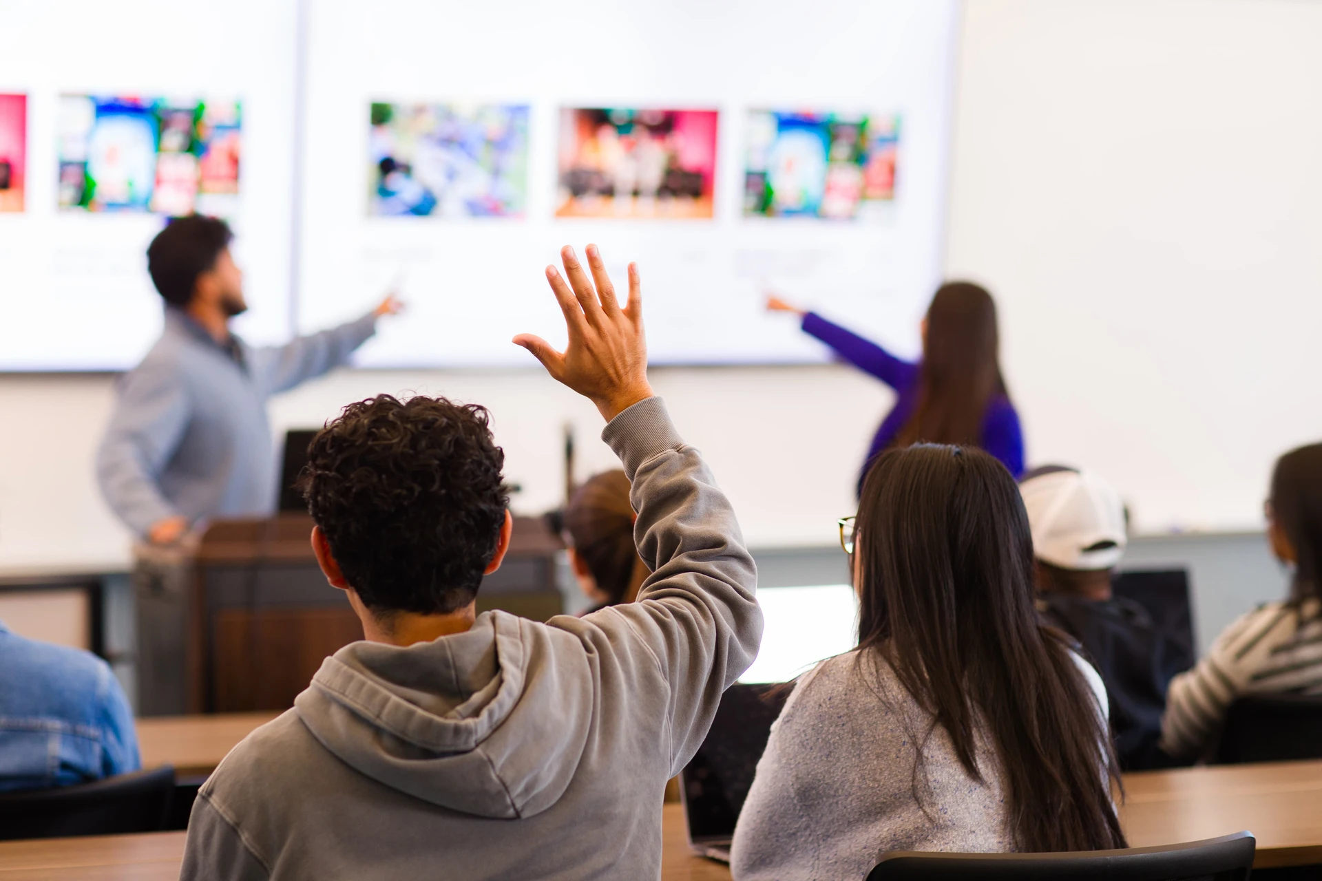 Student raising their hand to ask. for help in class