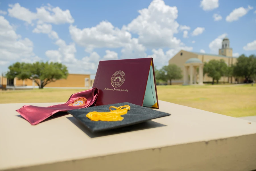 SWAU graduation diploma, sash, and cap aesthetic campus shot with clocktower